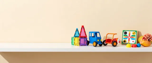 Magnetic tiles, two toy cars, a ludo board and play dough